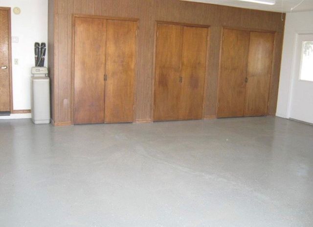 An empty room with wooden doors and a statue in the corner.