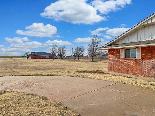 A brick house sits in the middle of a grassy field