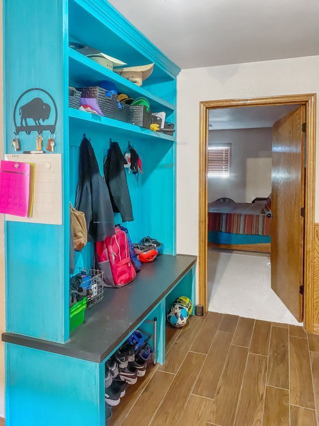 A hallway with a blue shelf and a soccer ball on the floor