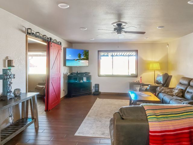 A living room with a red barn door and a flat screen tv