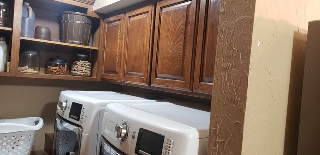 A laundry room with a washer and dryer and a basket.
