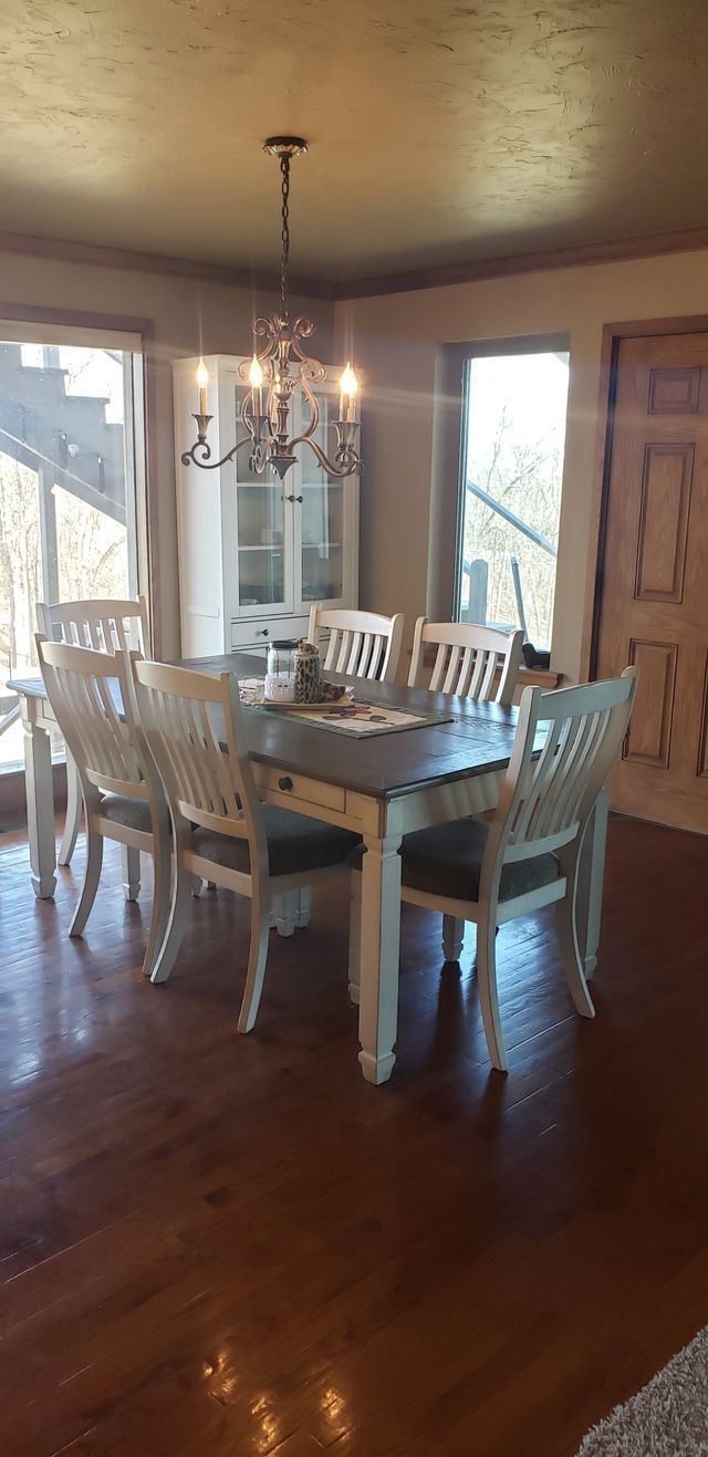 A dining room with a table and chairs and a chandelier.