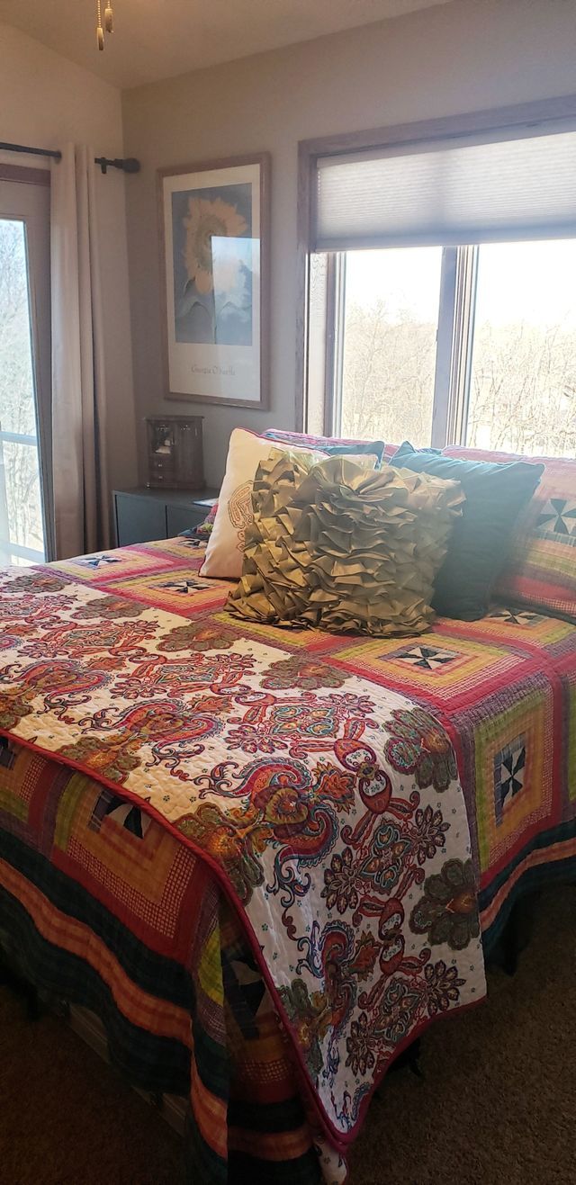 A bedroom with a king size bed and a window.