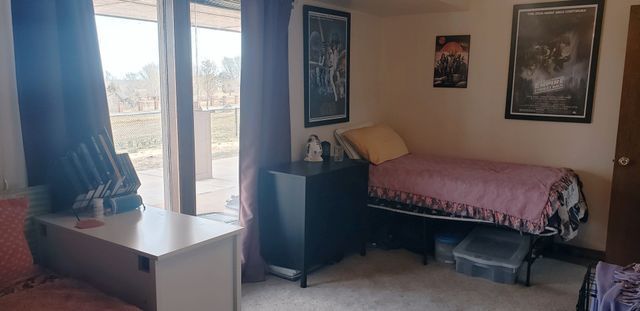 A bedroom with a bed , desk , and window.