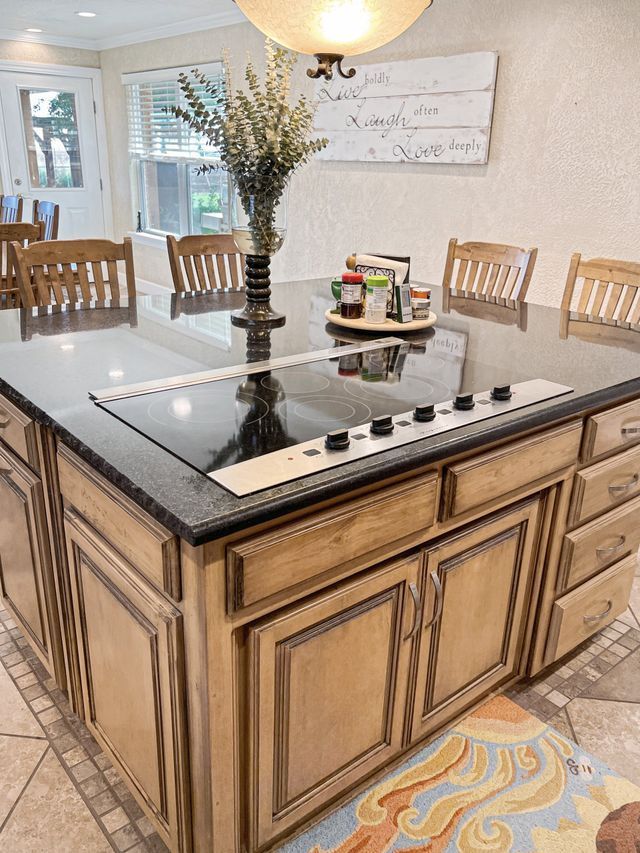 A kitchen with a large island and a stove top oven.