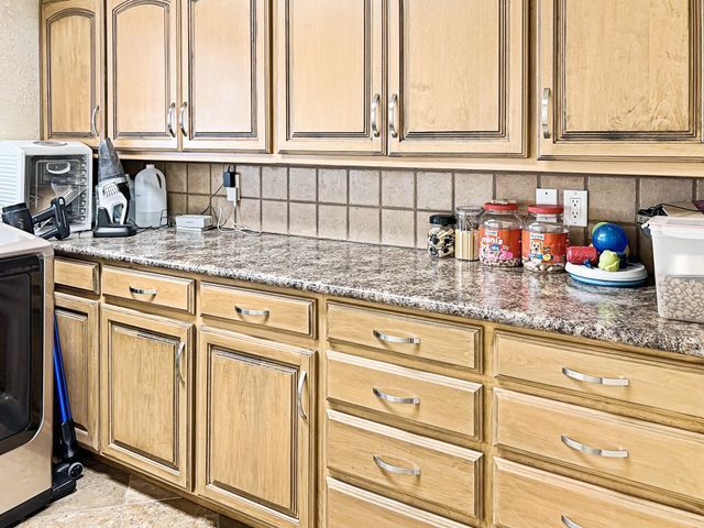 A kitchen with wooden cabinets and granite counter tops.
