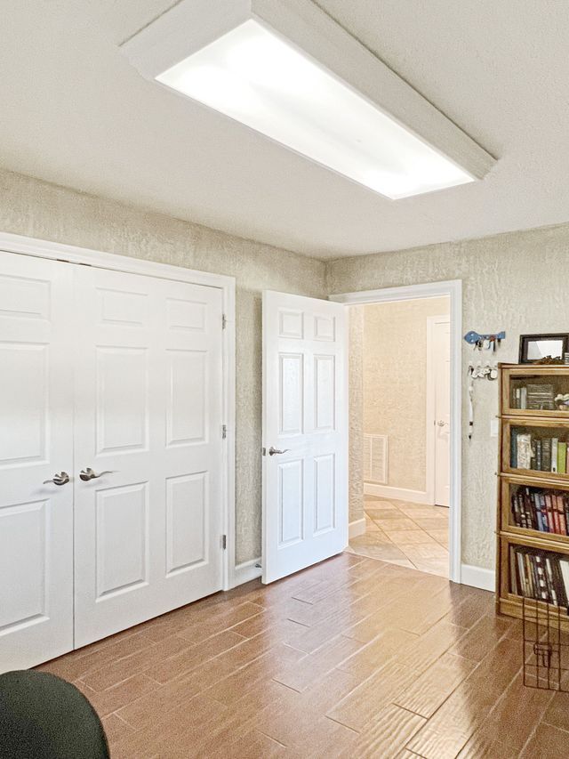 A room with white doors , a bookshelf , and a ceiling light.