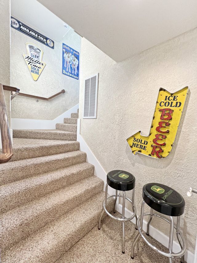 A staircase with a sign on the wall that says ice cold beer.
