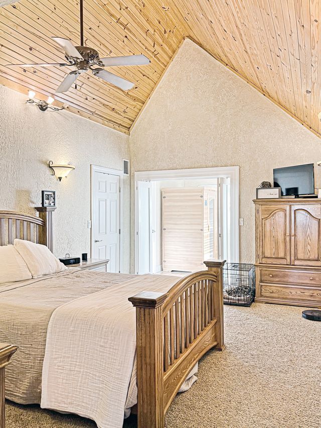 A bedroom with a bed and a ceiling fan