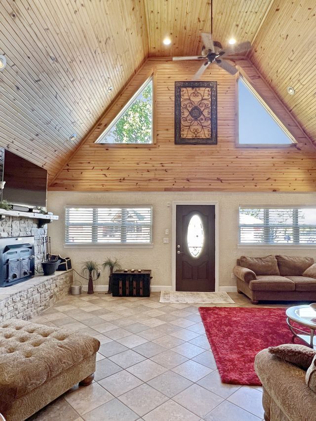 A living room with a vaulted ceiling and a fireplace