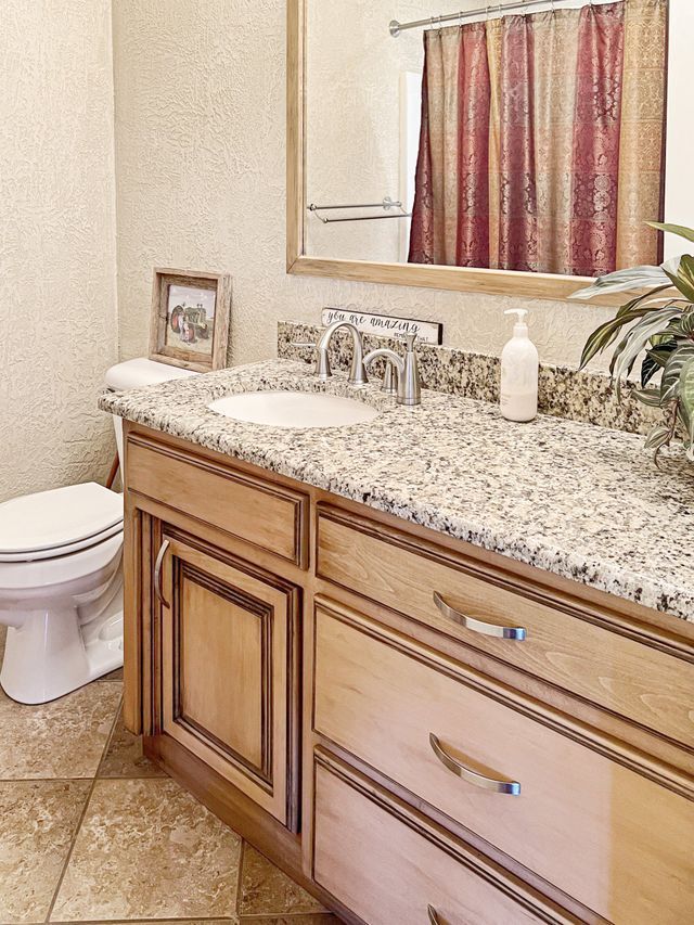 A bathroom with a sink a toilet and a mirror