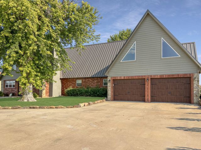 A house with two garage doors and a tree in front of it
