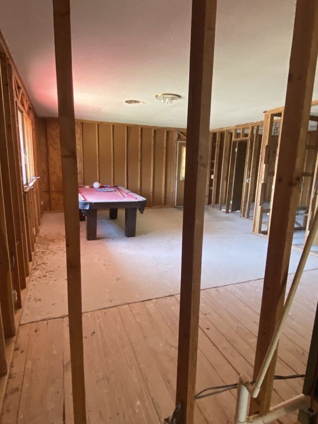 A pool table is sitting in a room under construction.