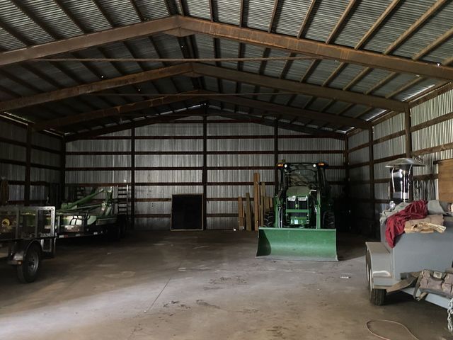 A tractor is parked inside of a metal building