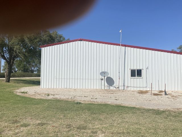 A white building with a red roof and a satellite dish on the side