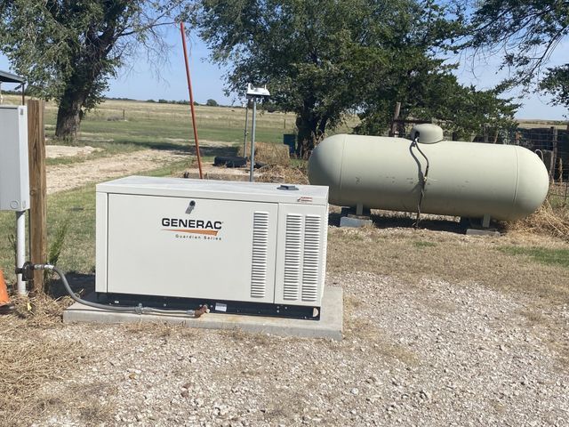 A generator is sitting next to a propane tank.