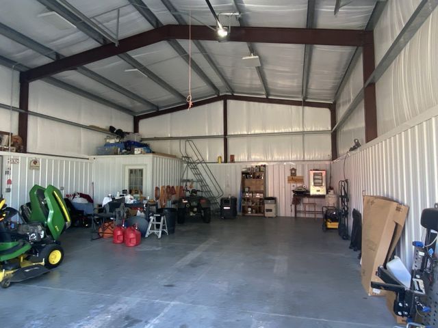 A john deere lawn mower is parked inside of a garage.
