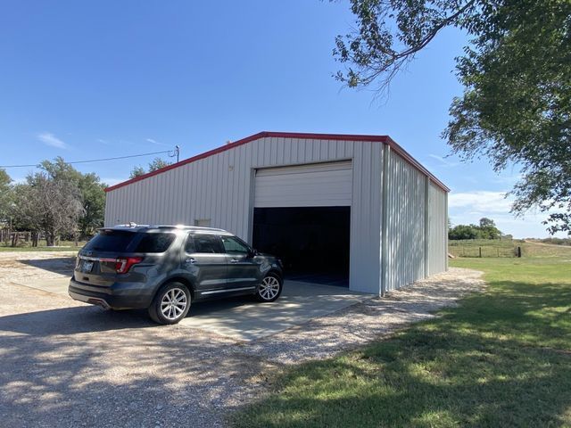 A car is parked in front of a metal garage.