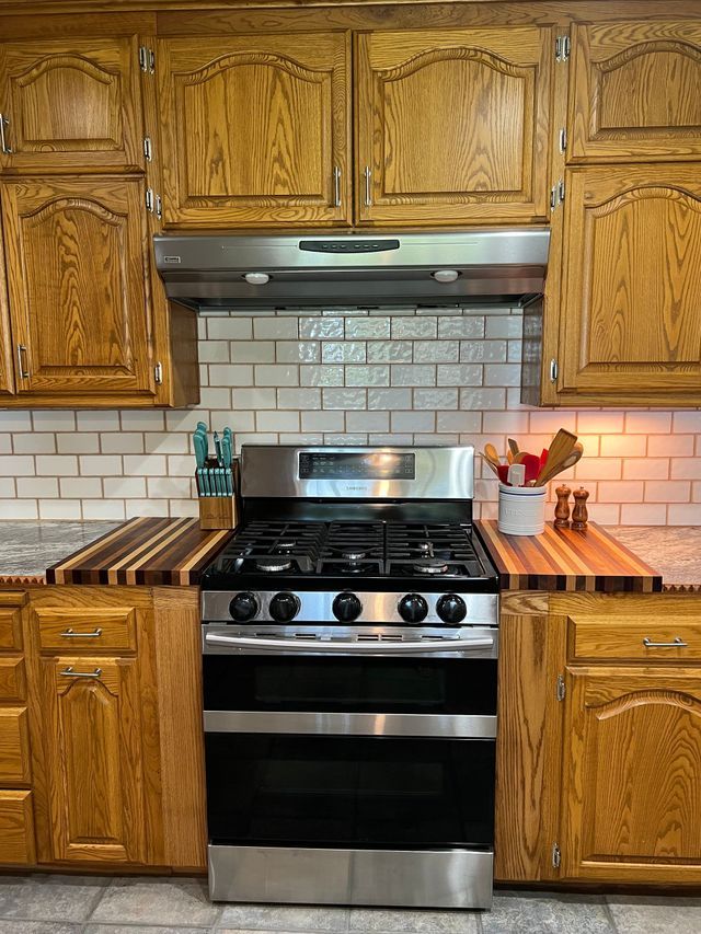 A kitchen with stainless steel appliances and wooden cabinets.