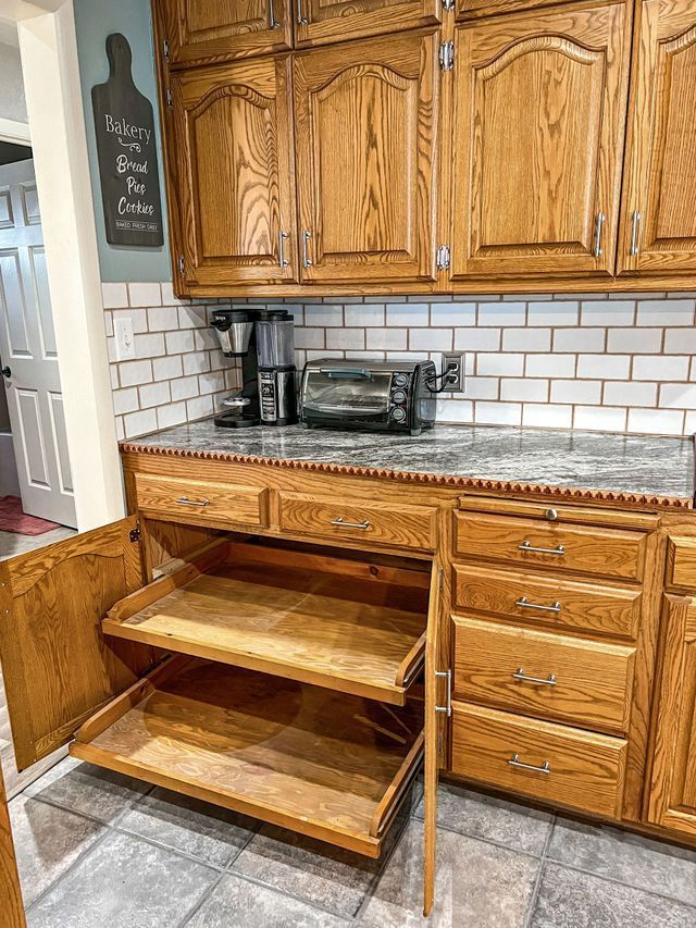 A kitchen with wooden cabinets and drawers and a toaster oven.