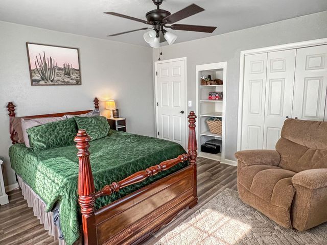 A bedroom with a bed , chair and ceiling fan.fire pit