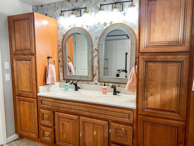 A bathroom with two sinks and two mirrors.