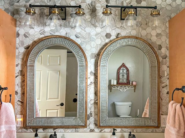 A bathroom with two mirrors and a toilet.