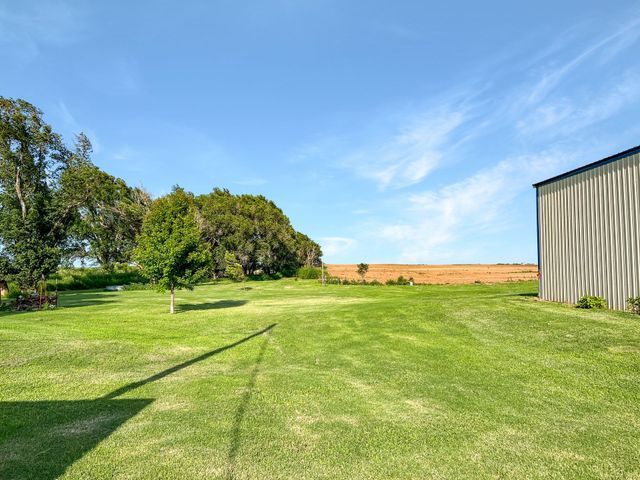 A large lush green field with a barn in the background.