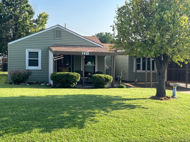 A small house with a large lawn in front of it.