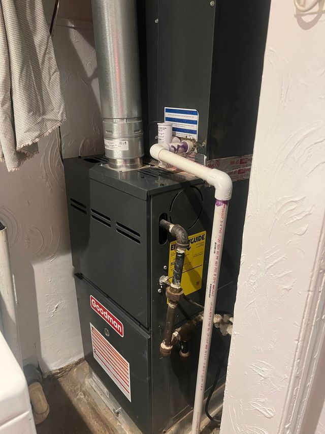 A gas heater is sitting in a room next to a wall.