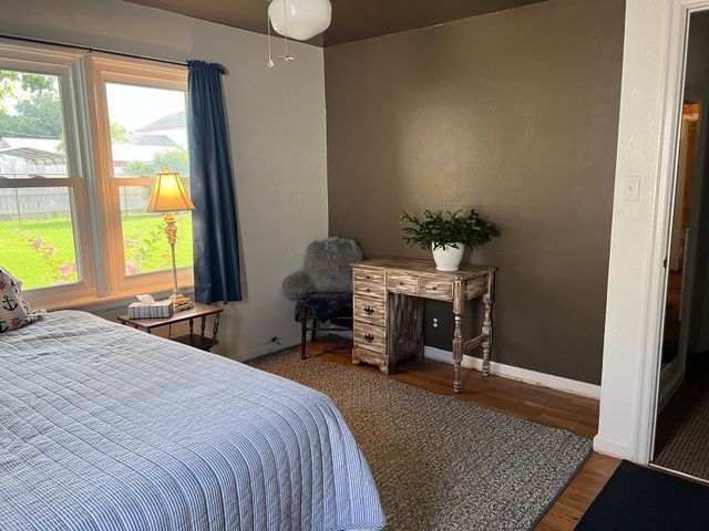 A bedroom with a bed , desk , chair and window.