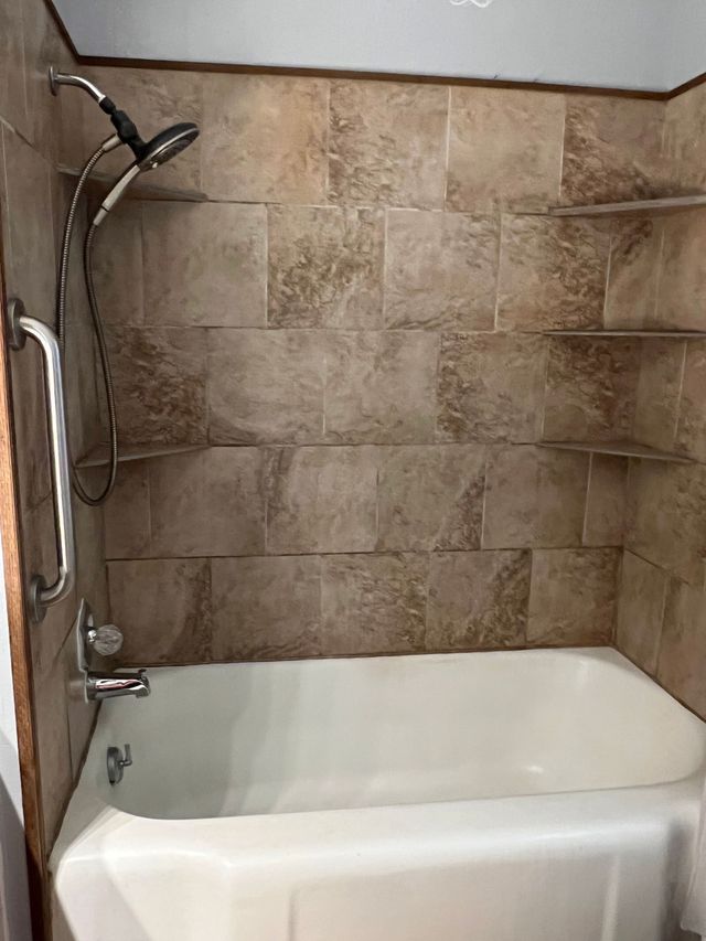 A bathroom with a bathtub and a shower.