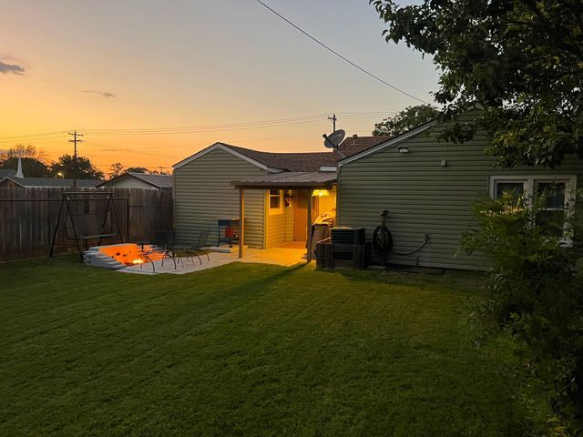 There is a fire pit in the backyard of a house.