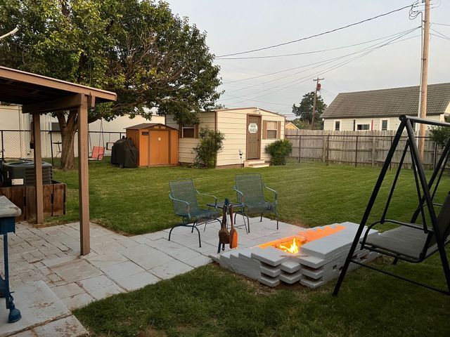 A backyard with a fire pit and a swing