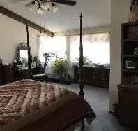 A bedroom with a four poster bed and a treadmill.