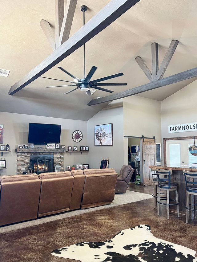 A living room with a cowhide rug and a ceiling fan