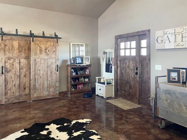 A living room with sliding barn doors and a cow print rug.