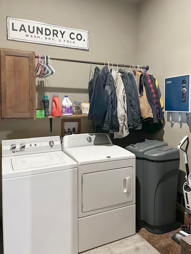 A laundry room with a washer and dryer and a sign that says laundry co.