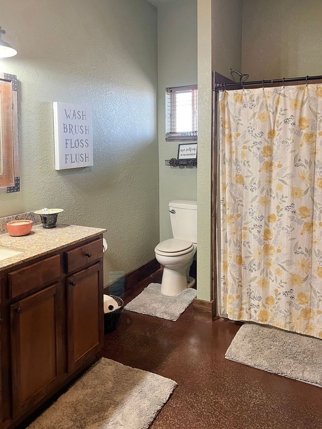 A bathroom with a toilet , sink , and shower curtain.