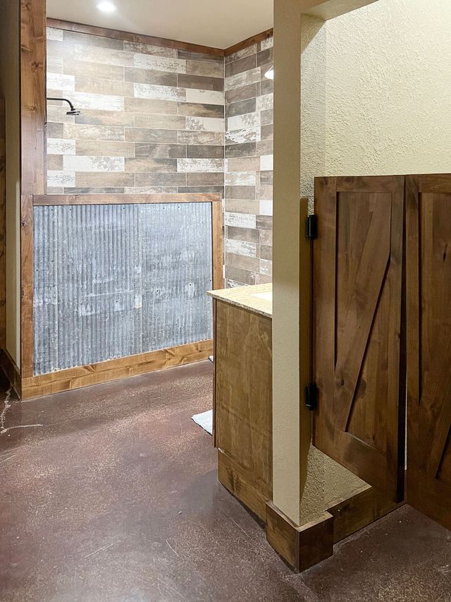 A bathroom with a wooden cabinet and a wooden door.