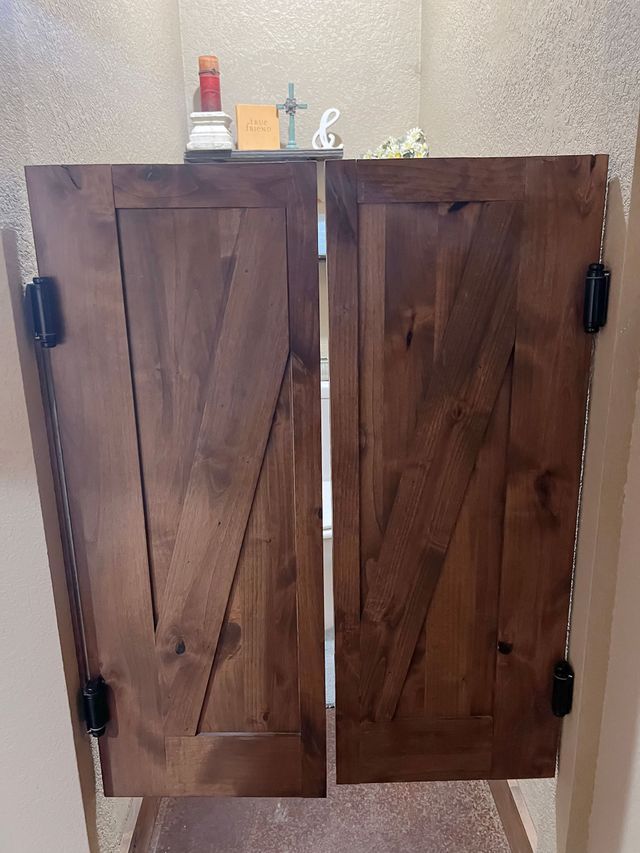 A pair of wooden doors are open in a hallway.