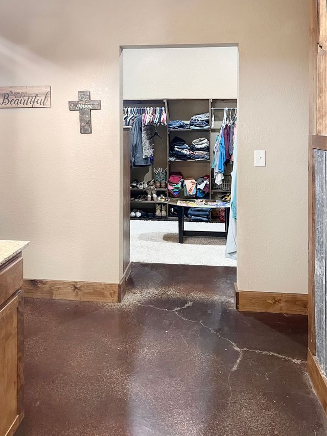 A hallway leading to a closet with a cross on the wall.