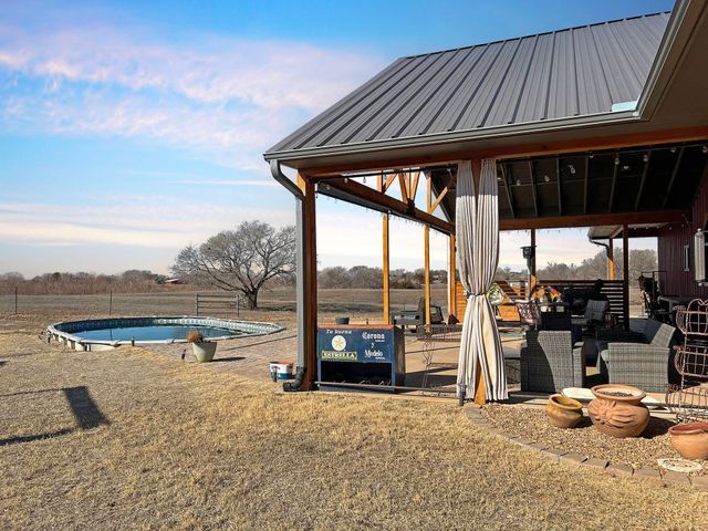 A house with a covered patio and a pool in the backyard.