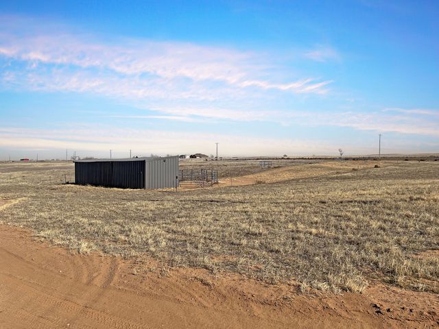 There is a small building in the middle of a field.