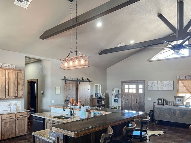 A kitchen with a large island and a ceiling fan.