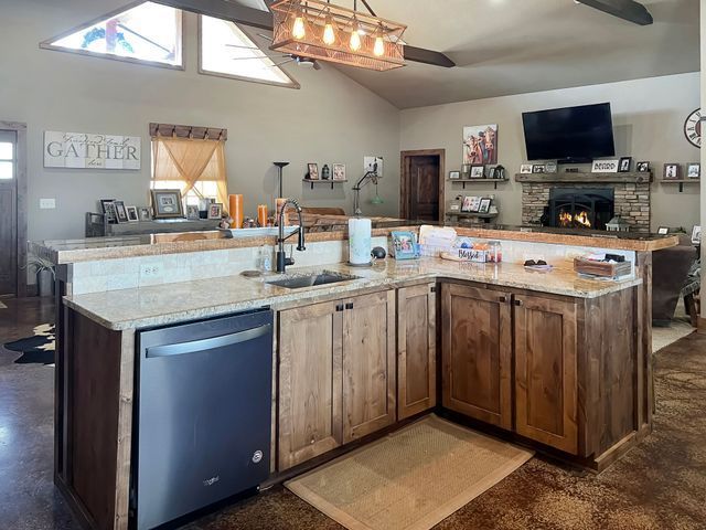 A kitchen with a sink , dishwasher , and television.