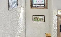 A room with a stained glass window and a picture on the wall.