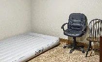 There is a chair and a mattress in the room.