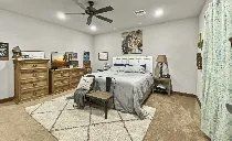 A bedroom with a bed , dresser , nightstand and ceiling fan.