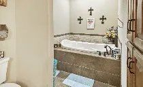 A bathroom with a tub , toilet , and shower.